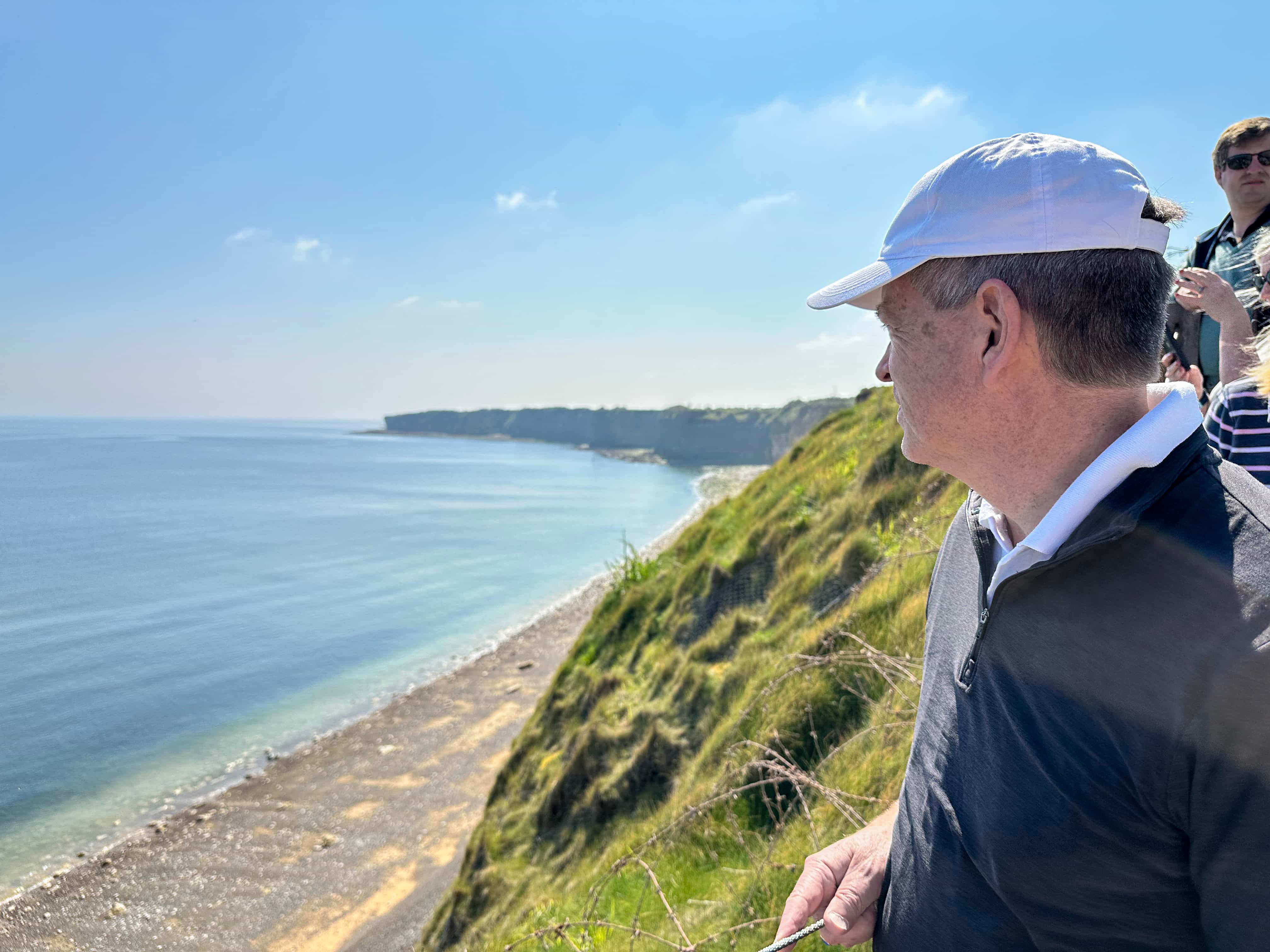 A traveler looking out over the Normandy coast and cliffs on a 2025 D-Day tour