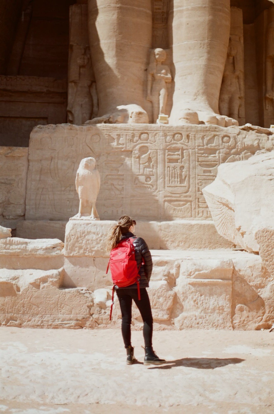 A traveler dwarfed by the colossi on the facade at Abu Simbel