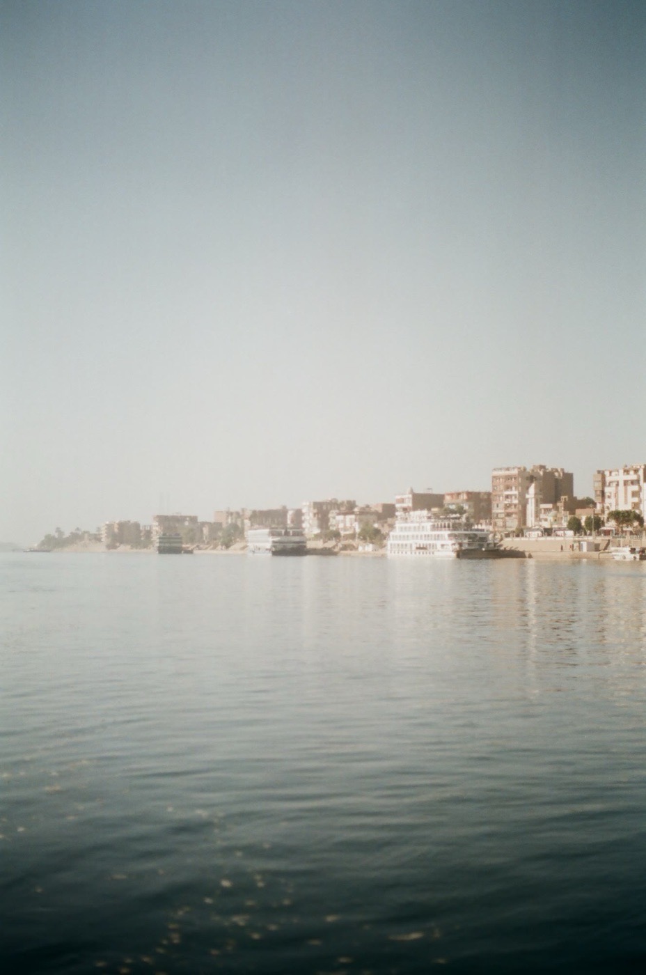 The Aswan waterfront under haze, seen across the Nile