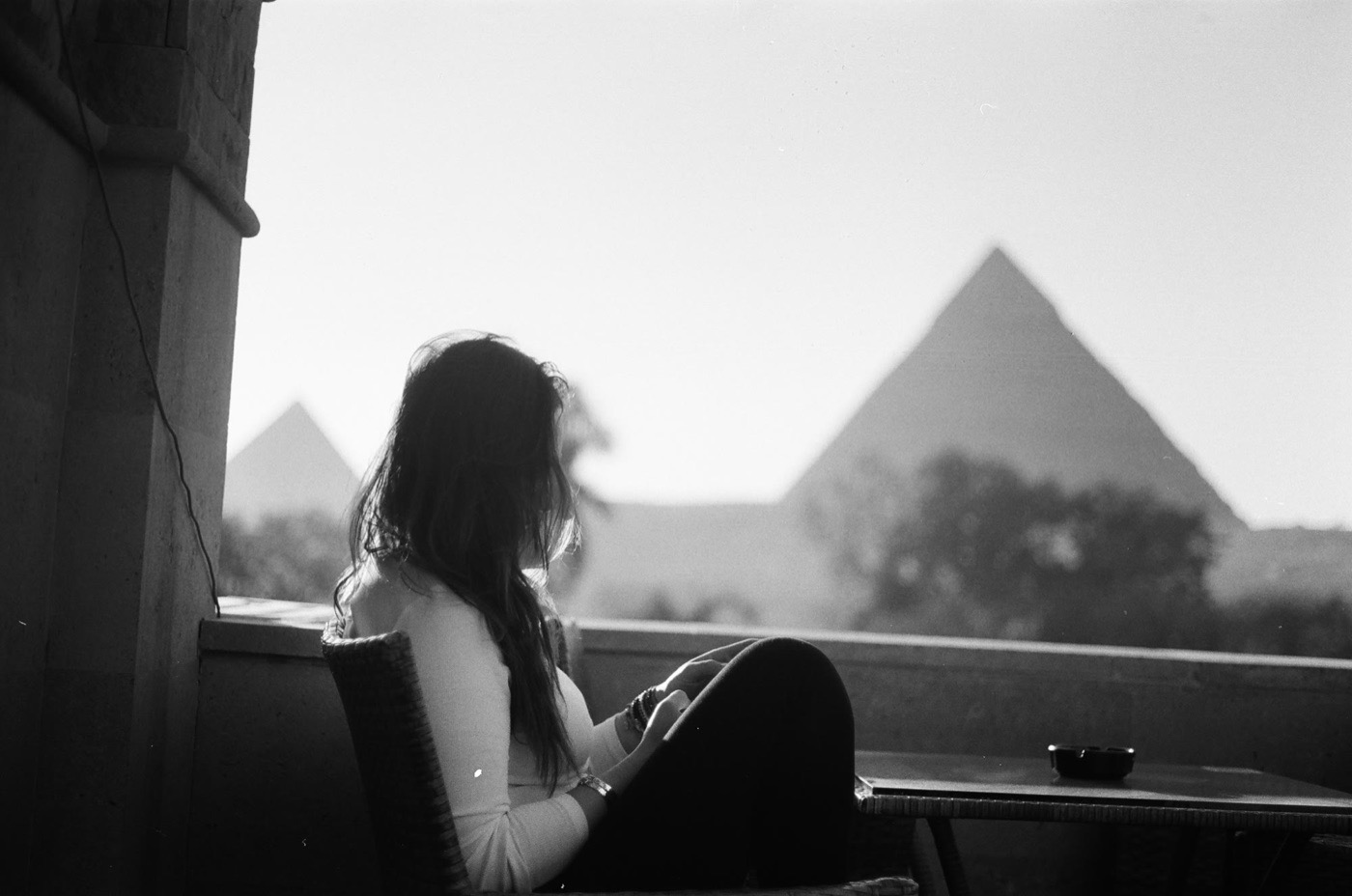 The pyramids of Giza seen from a hotel balcony at dusk, shot on black and white film