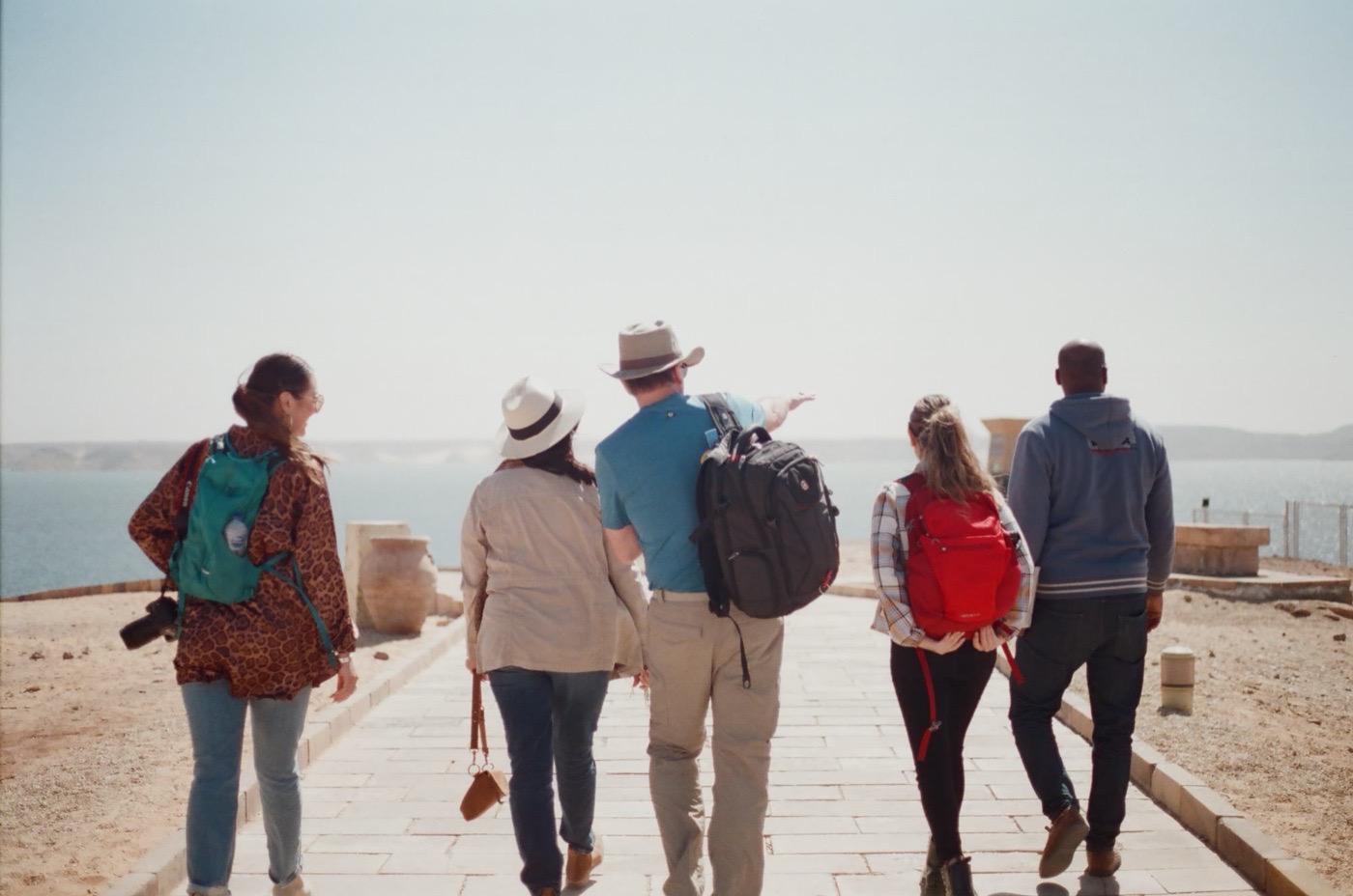 The group walking in along the water with their guide pointing the way ahead