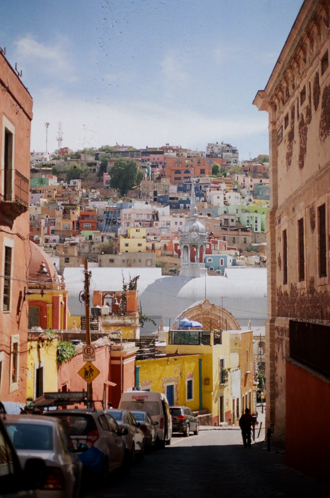 A Guanajuato street running down toward the coloured houses on the hill