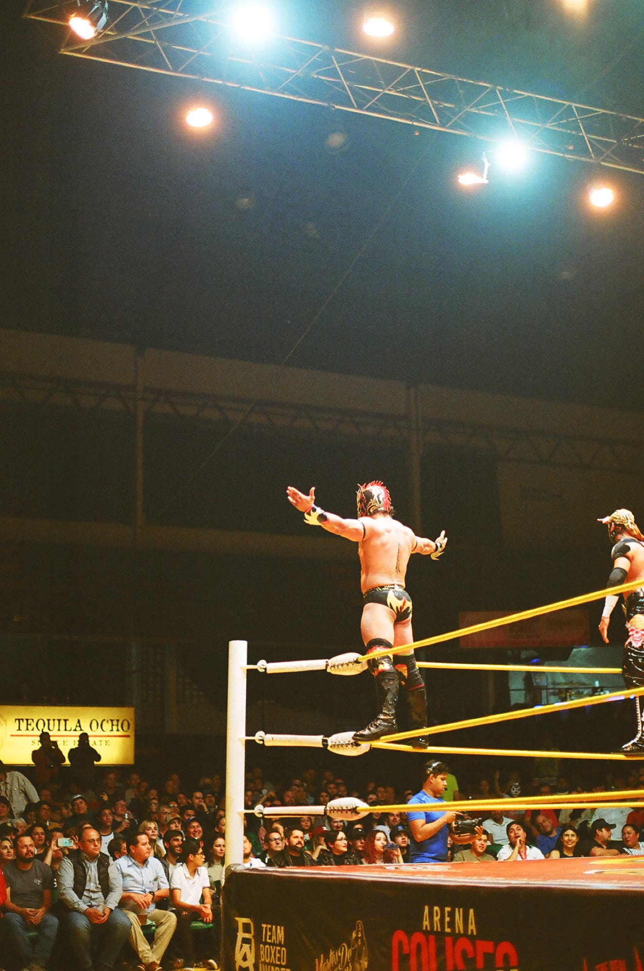 A luchador working the crowd from the ropes at Arena Coliseo