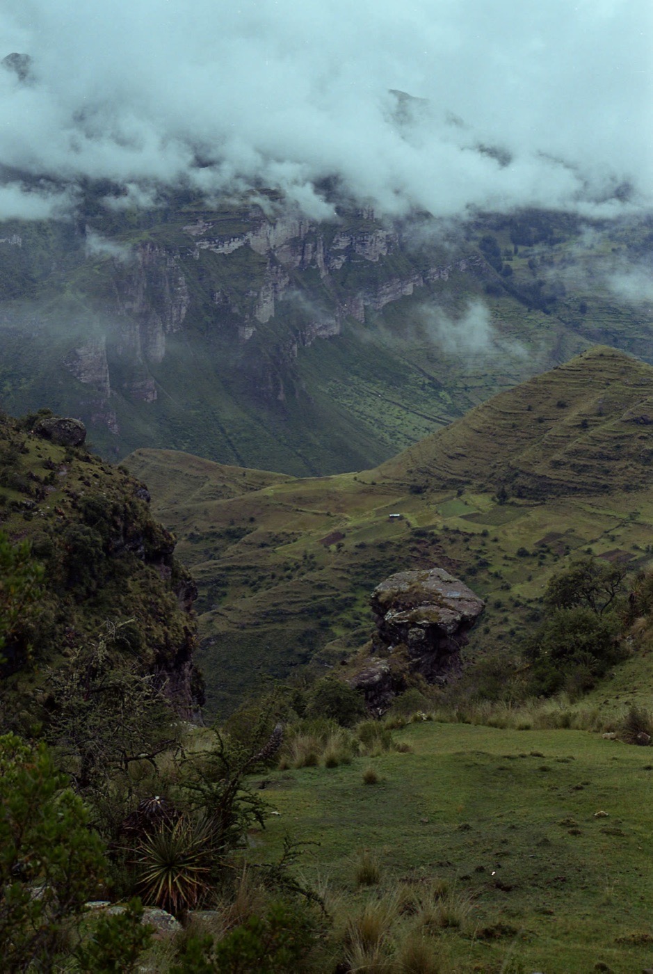 Cloud sitting low over a green Andean valley