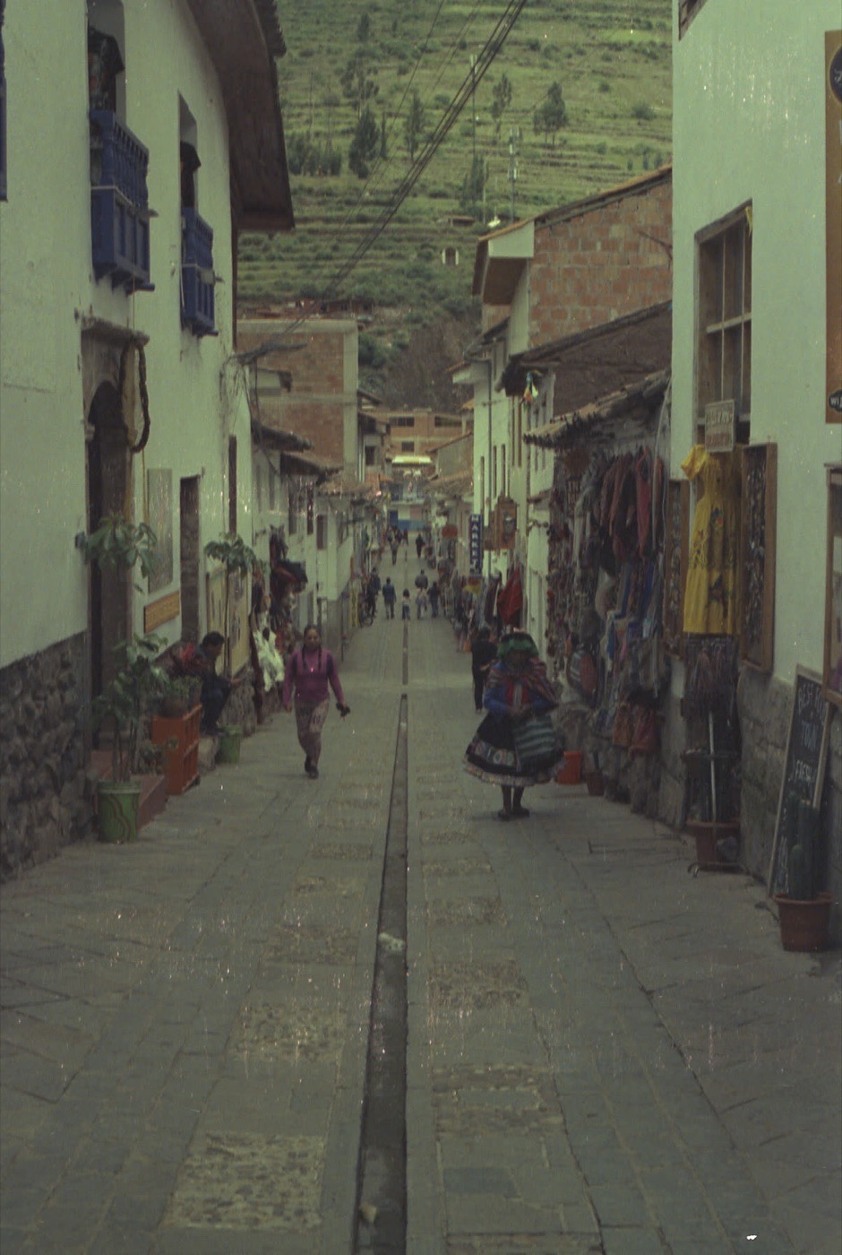 Walkers on a cobbled colonial street in Cusco