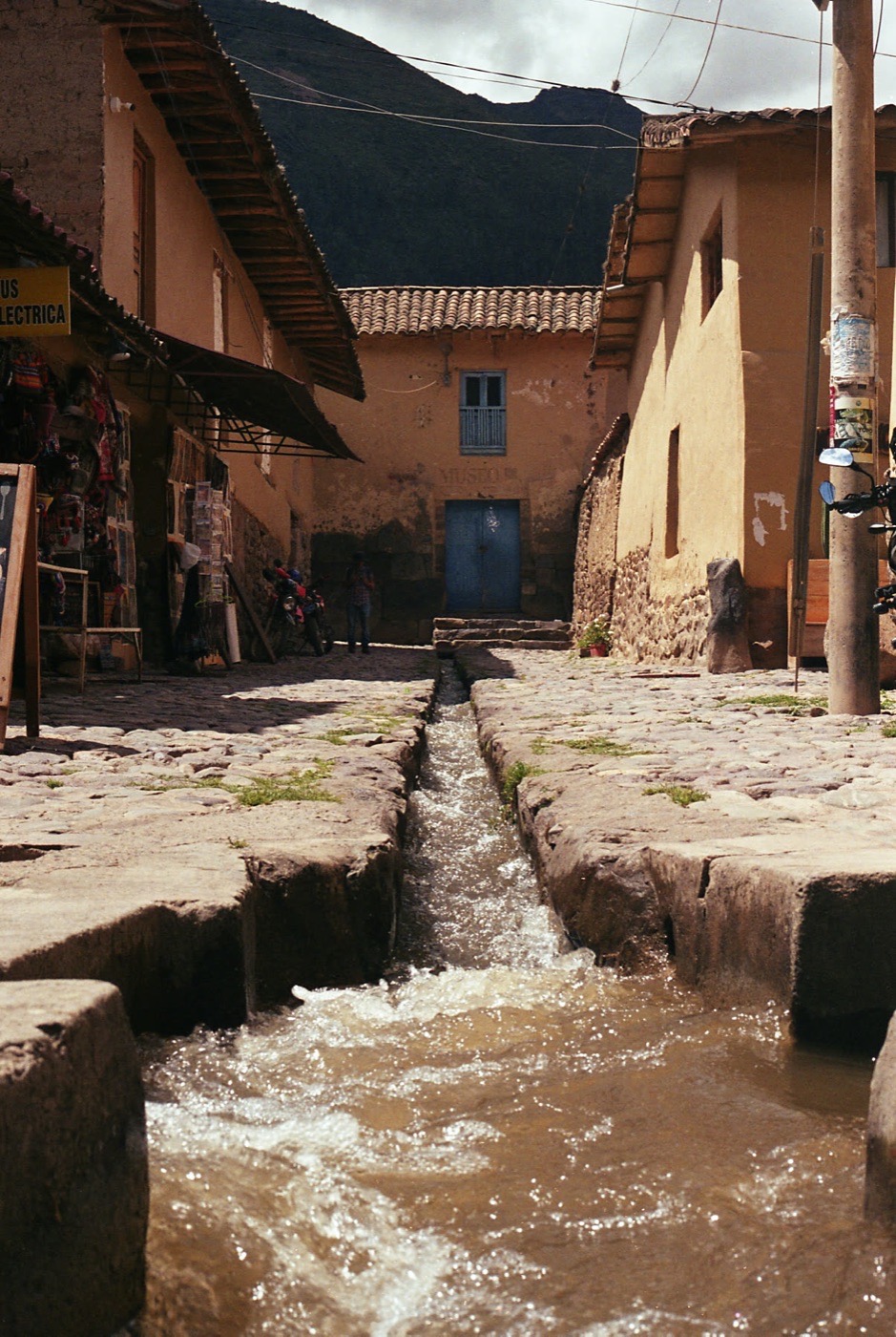 Water running the channel of a colonial street, in black and white