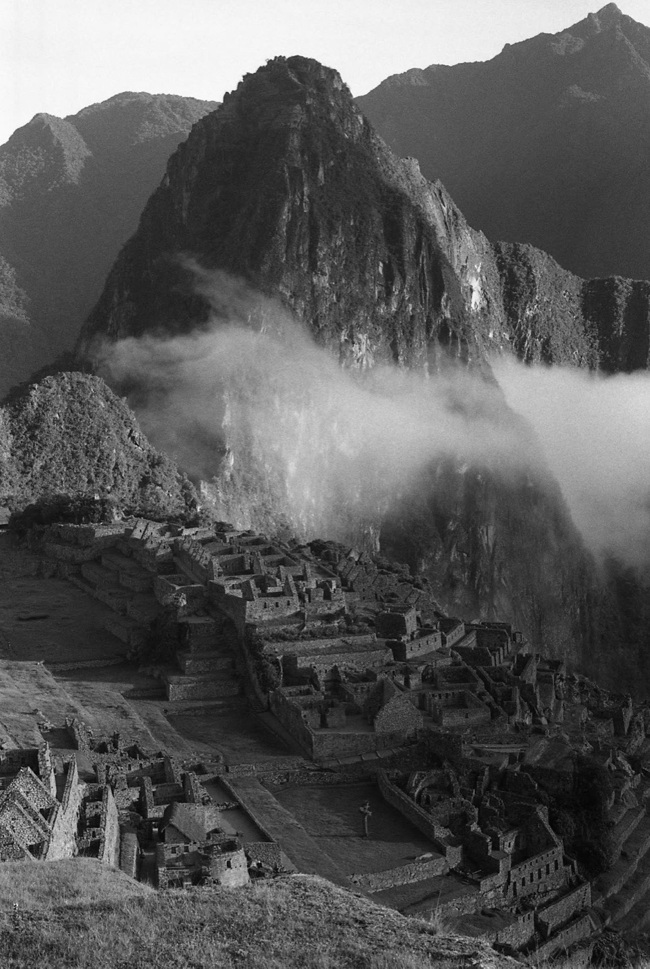 Machu Picchu with the peak behind it, mist in the valley