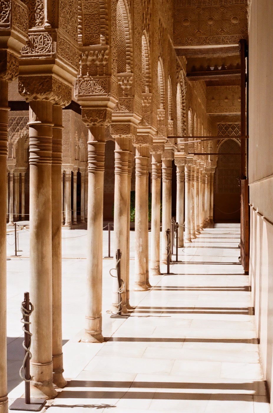 Marble columns and carved capitals along a courtyard at the Alhambra